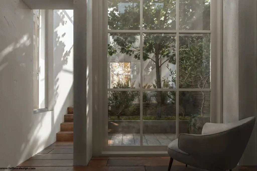 A room with a large window and a chair, transformed into a stunning 3D interior design.