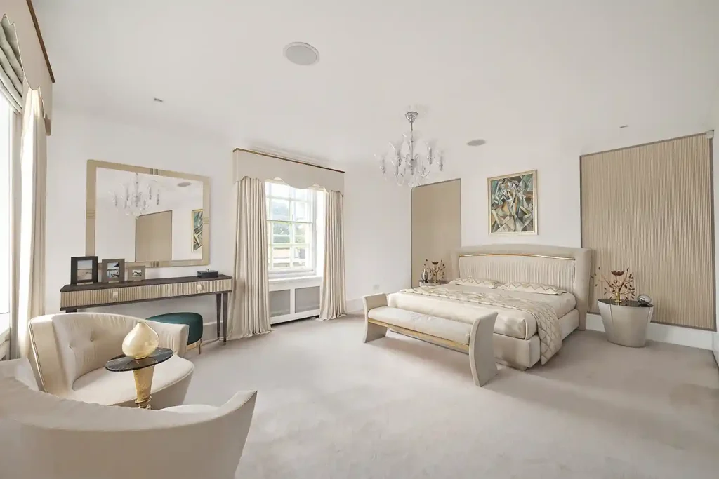 A high-end bedroom with a large bed and a chandelier, expertly staged virtually to exude luxury.