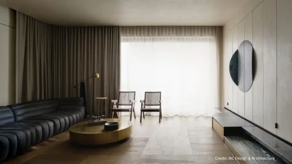 A living room with black leather furniture and a round table showcasing a touch of wabi sabi style.