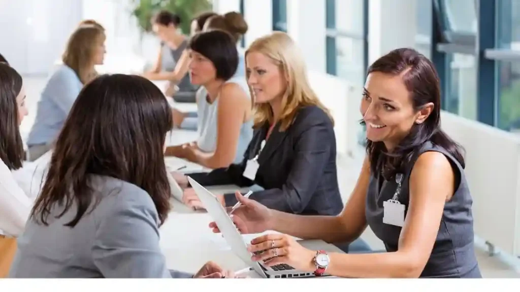 A group of women sitting at a table chatting about job positions with each other in Philly.