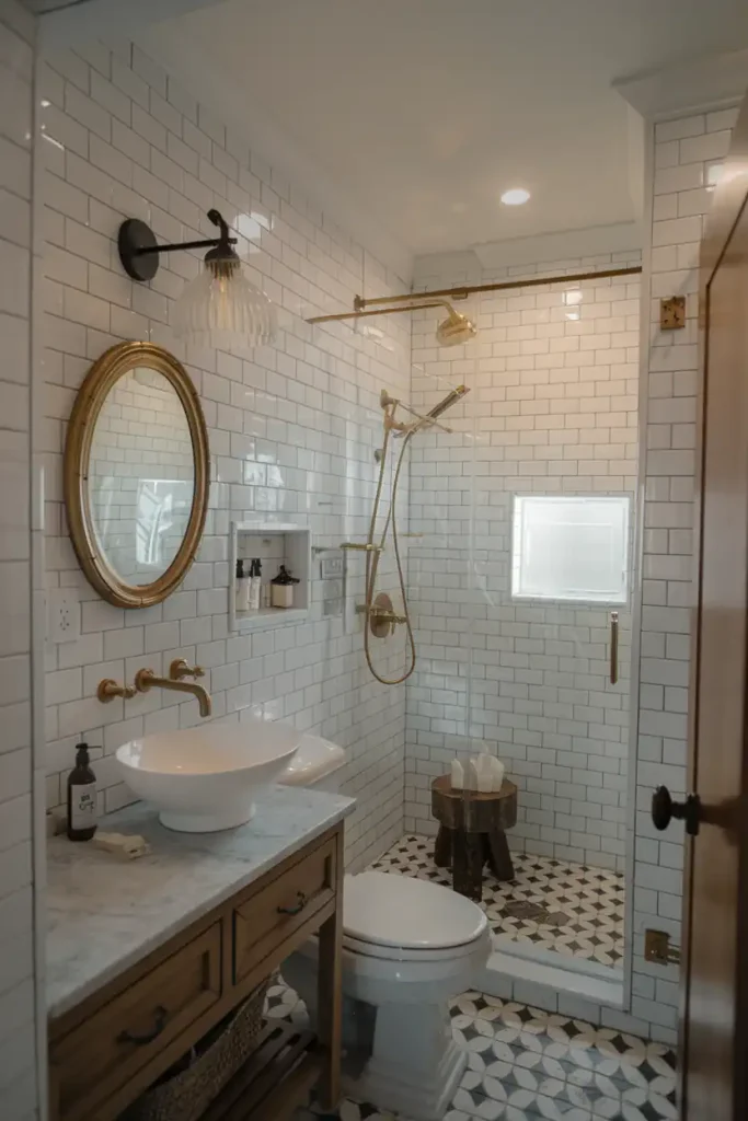 Modern bathroom with white subway tiles, round mirror, gold fixtures, shower with glass door, and a patterned tile floor showcasing the best of contemporary bathroom flooring.