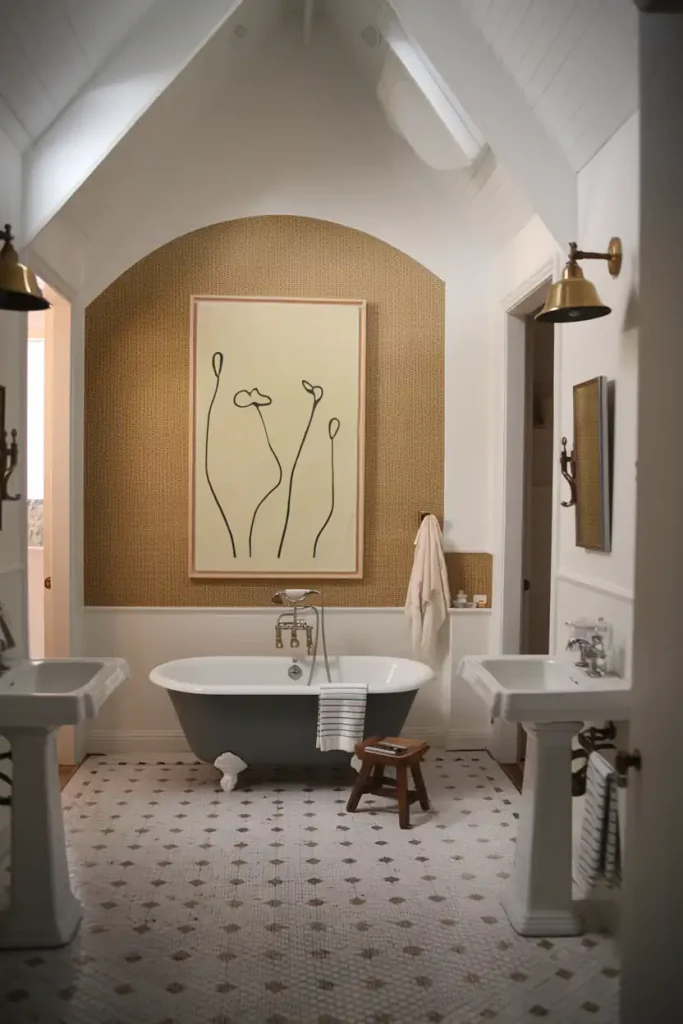 Elegant bathroom with a freestanding bathtub, pedestal sinks, wall art, and soft lighting. White and neutral tones dominate, complemented by carefully chosen bathroom flooring materials that blend seamlessly into the design.