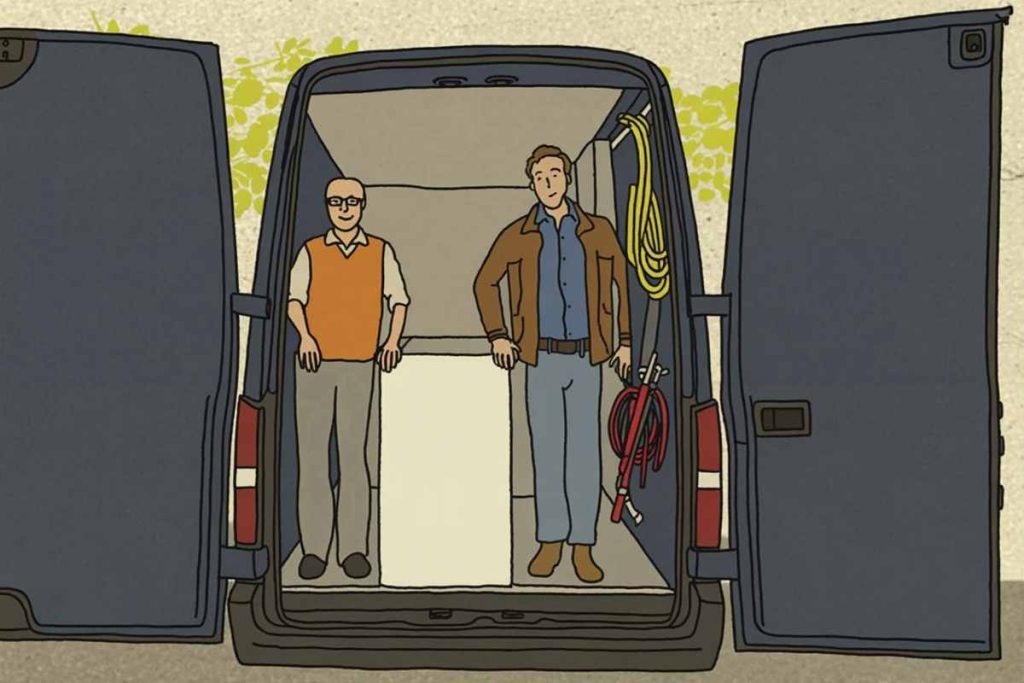 Two men stand in the back of an open van, facing forward, with renovation equipment hanging on the right wall.