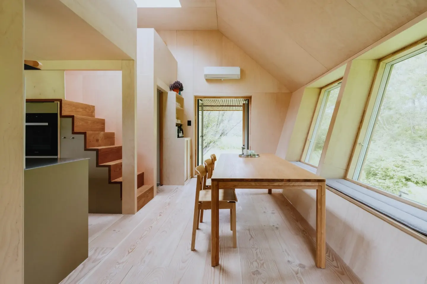 EcoNeo interior showing the central storage staircase, timber joinery, rooflight and sleeping mezzanines inside 35 m²