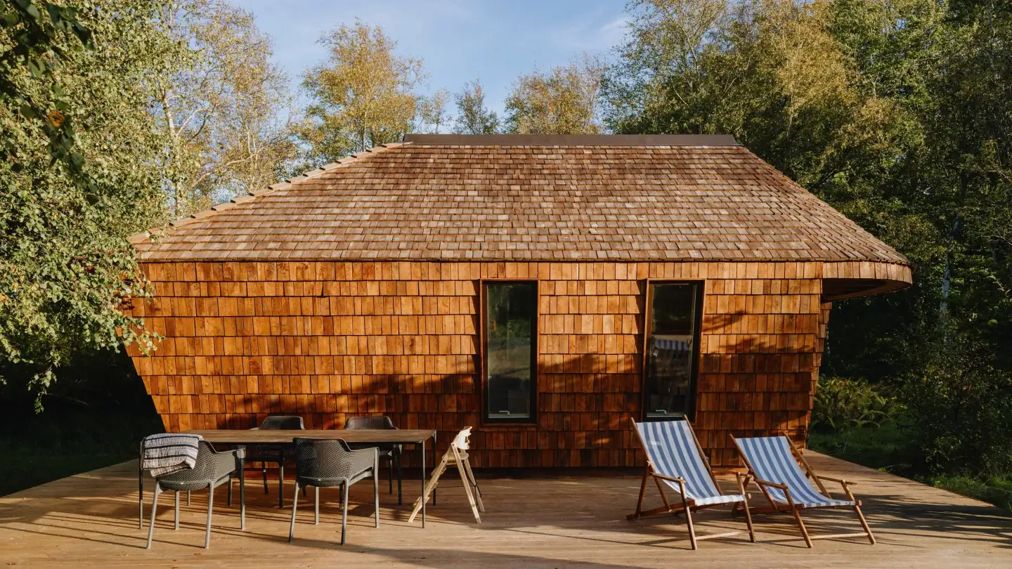 EcoNeo 35 m² summerhouse in North West Zealand with a dark timber exterior and glazed terrace frontage