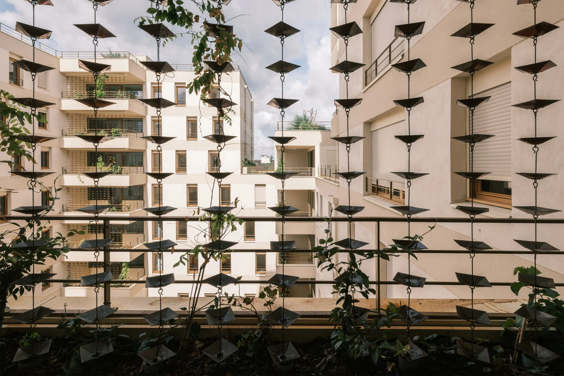 Interior garden of Paysage Habité with cable structures for climbing plants around bicycle platforms